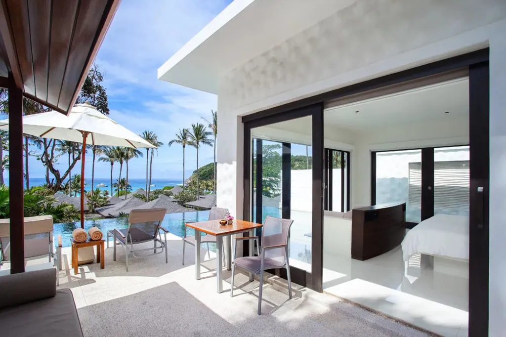 Terrasse aménagée avec mobilier de jardin et vue sur la mer.