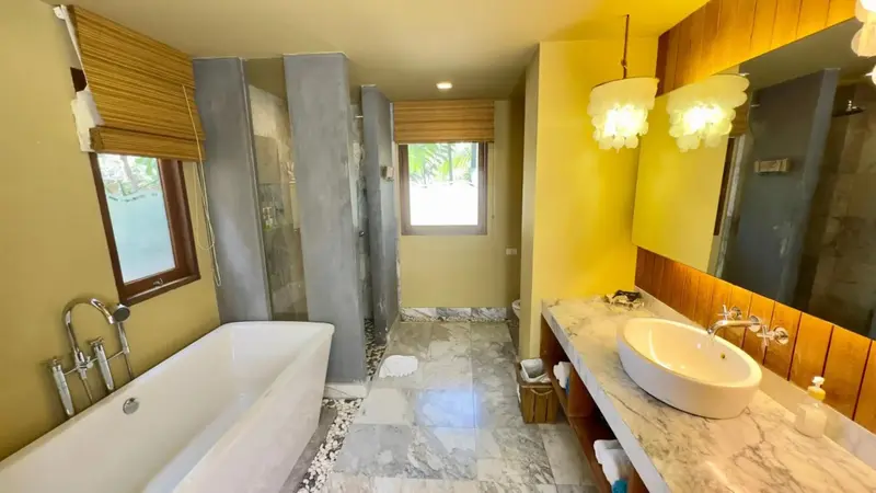 Une salle de bain lumineuse avec baignoire et douche à l'italienne.