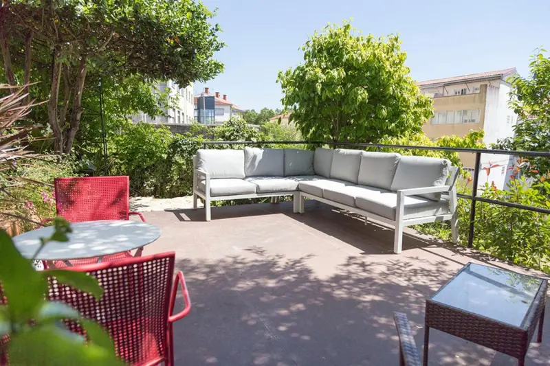 Terrasse aménagée avec salon et table à manger en extérieur.