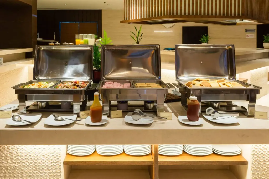 Un buffet propose une variété de plats chauds et de sauces.