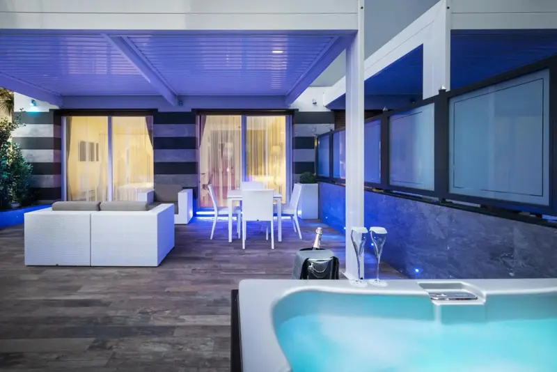 Espace de détente extérieur avec canapés blancs et table à manger.