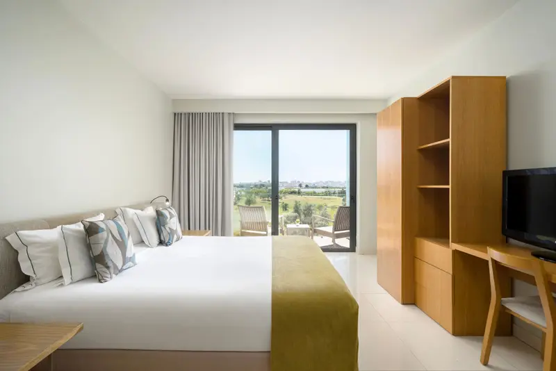 Une chambre lumineuse avec un grand lit et un accès à une terrasse.