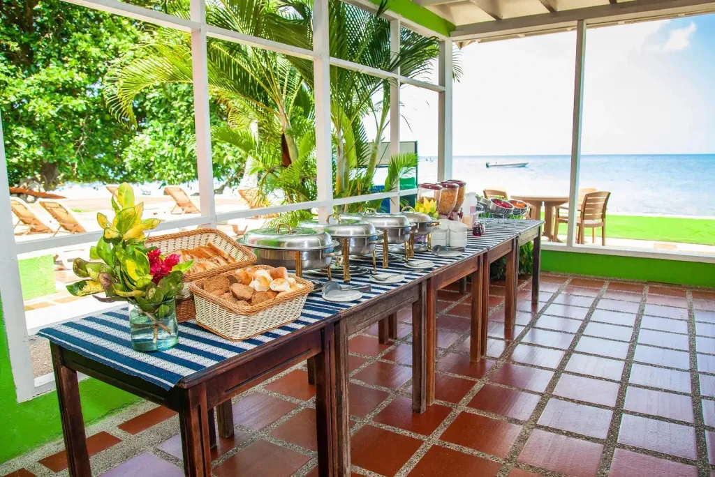 Un buffet propose des plats variés dans un espace lumineux et ouvert sur la mer.