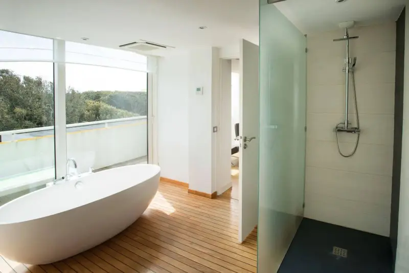 Une salle de bain lumineuse avec baignoire et douche à l'italienne.