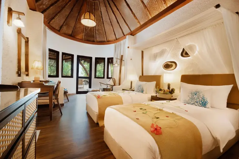 Une chambre lumineuse avec deux lits simples et une décoration tropicale.
