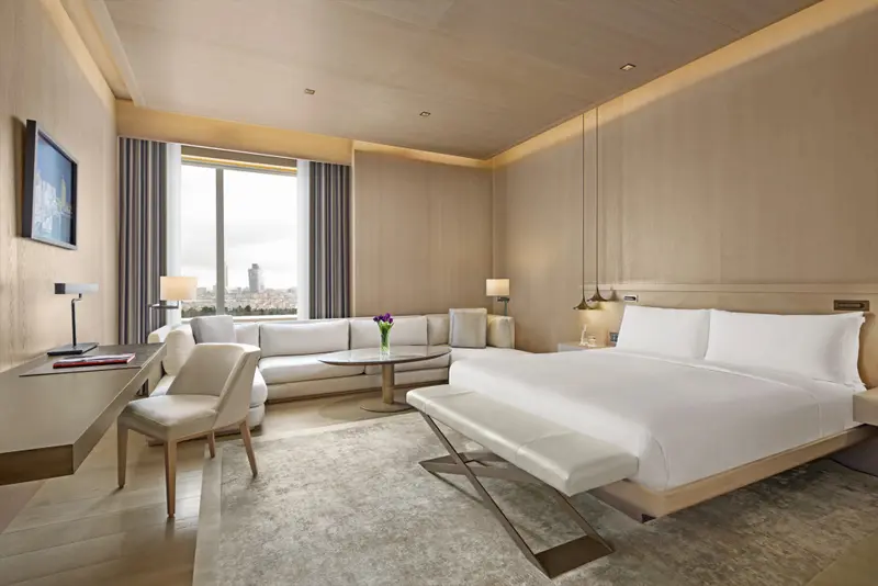 Une chambre lumineuse avec un grand lit et un coin salon.