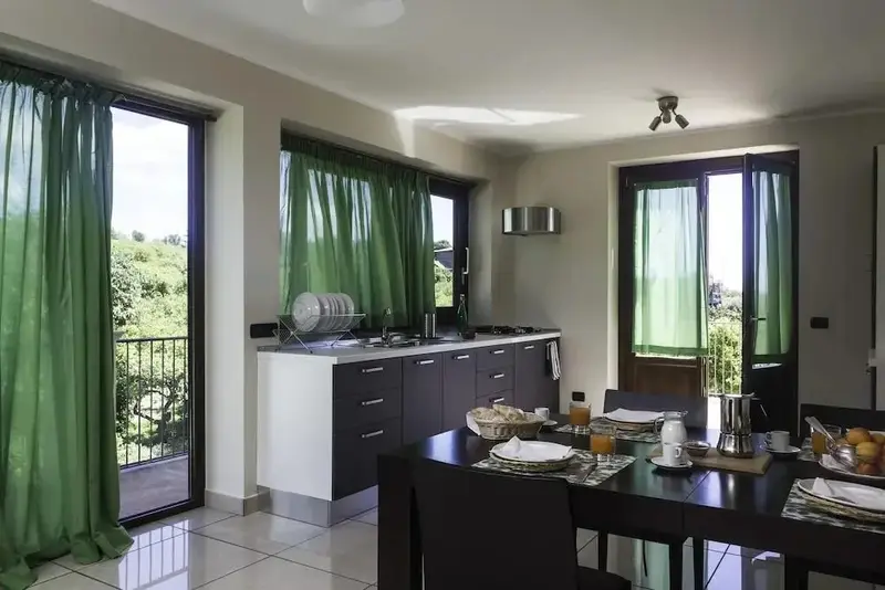 Une cuisine moderne s'ouvre sur une terrasse verdoyante.