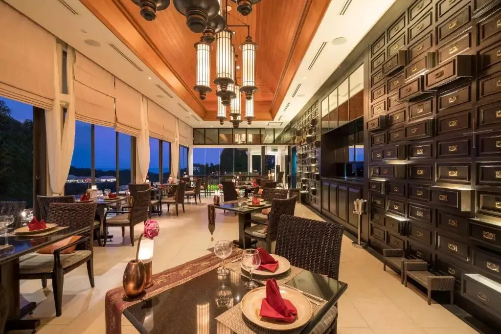 Une salle de restaurant élégante avec des tables dressées et une vue sur le paysage.