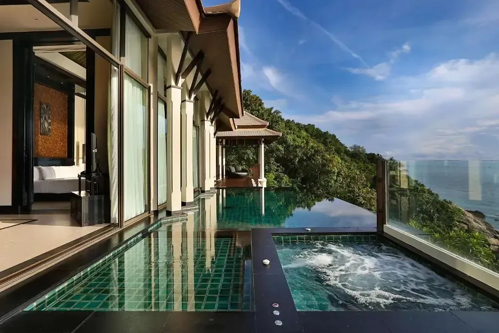 Une piscine à débordement offre une vue sur la mer depuis une terrasse.