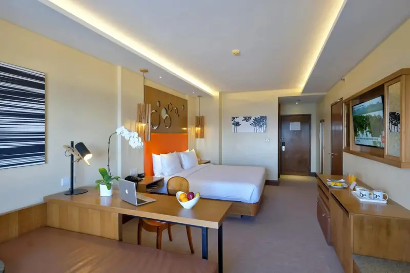 Une chambre lumineuse avec un grand lit et un bureau.