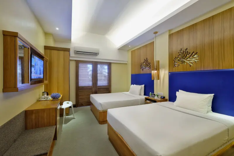Une chambre lumineuse avec deux lits simples et une décoration murale en bois.