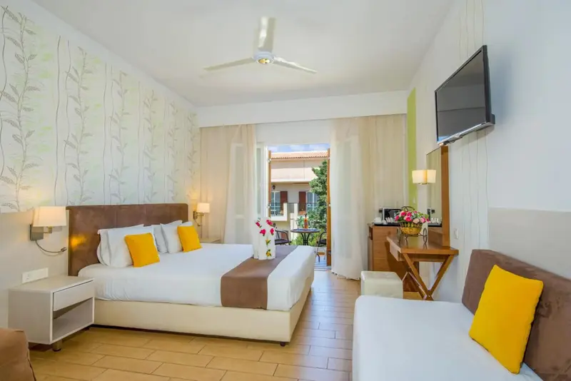 Une chambre lumineuse avec un grand lit et un coin salon.