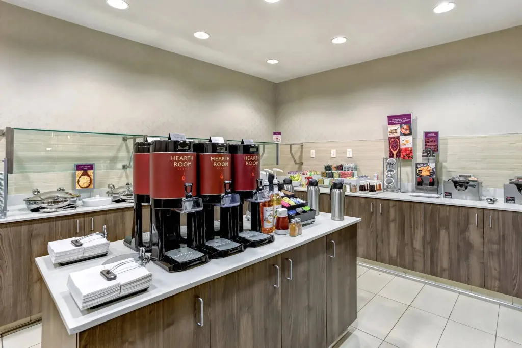 Un comptoir de buffet propose des boissons chaudes et des accompagnements pour le petit-déjeuner.