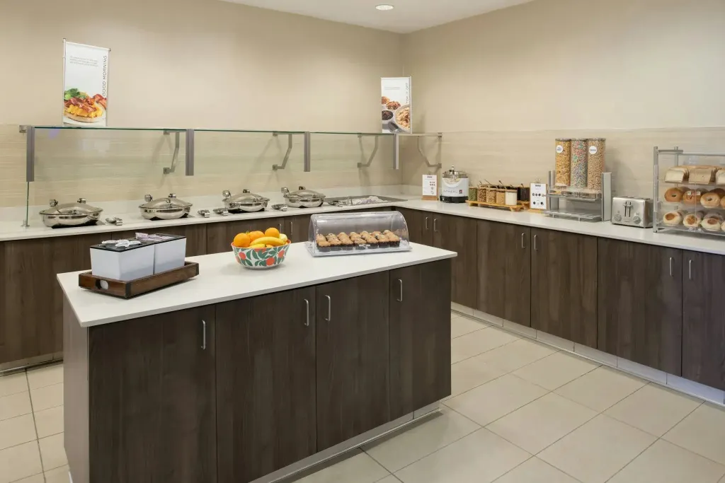 Un buffet propose une variété de plats et de pâtisseries dans un espace lumineux.