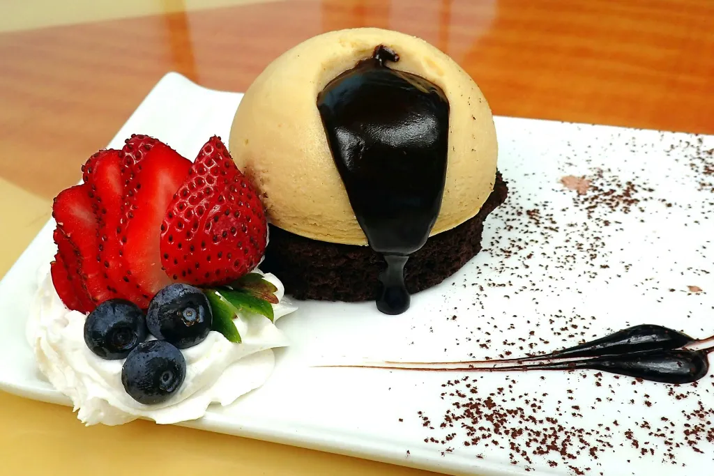 Une présentation gourmande avec des fraises, des myrtilles et une crème onctueuse.