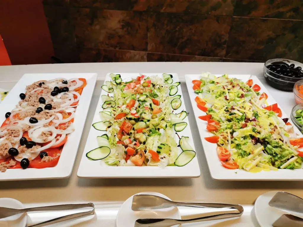Assortiment de salades colorées présentées sur un buffet.
