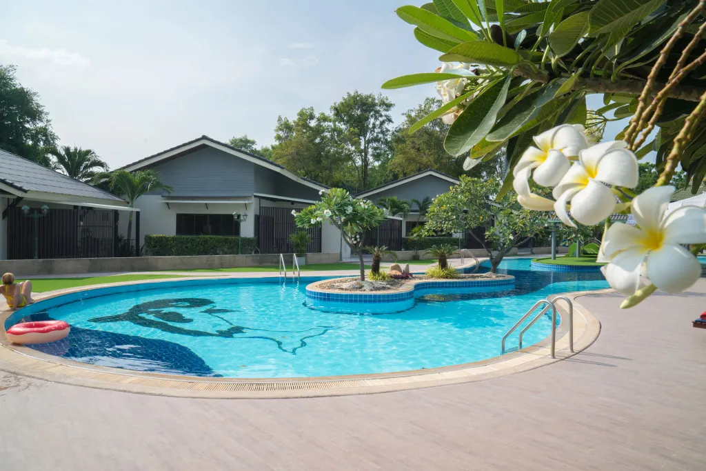 Une piscine rectangulaire avec un îlot central et des transats sur une terrasse.