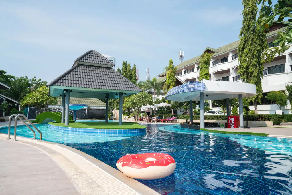 Une piscine avec des parasols et des transats dans un complexe hôtelier.