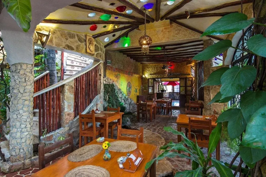 Une salle à manger lumineuse avec des tables en bois et des décorations colorées.