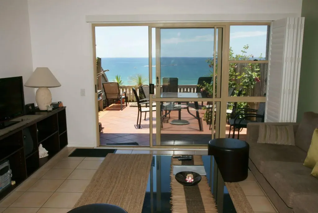 Un salon lumineux s'ouvre sur une terrasse avec vue sur la mer.