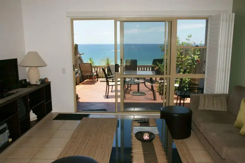 Un salon lumineux s'ouvre sur une terrasse avec vue sur la mer.