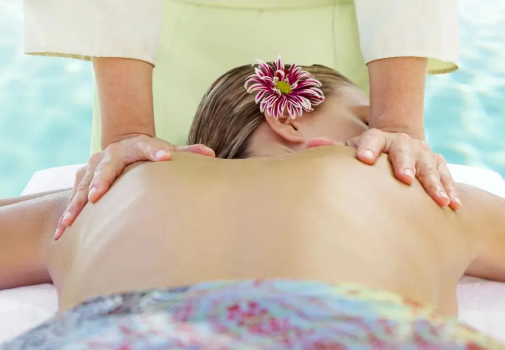 Une personne reçoit un massage sur une table de soin.
