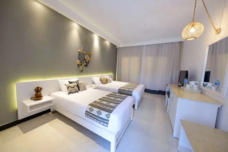 Une chambre lumineuse avec deux lits simples et une décoration sobre.