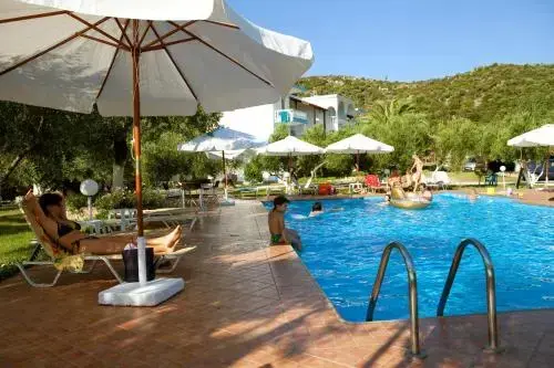Transats blancs disposés au bord d'une piscine ensoleillée.