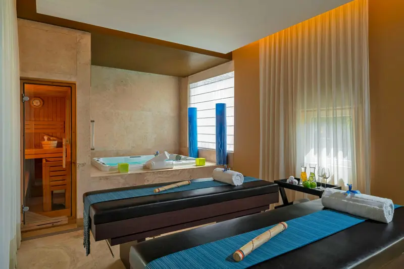 Espace de soins avec tables de massage et baignoire à remous.