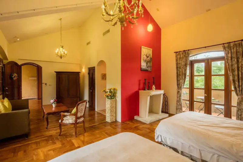 Vaste chambre lumineuse avec un canapé et un accès à une terrasse.