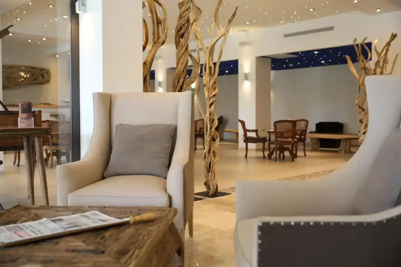 Un espace de détente intérieur avec des fauteuils confortables et une décoration naturelle.
