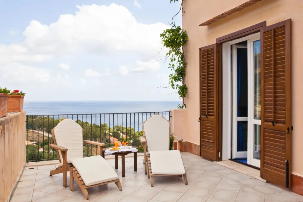 Terrasse avec deux fauteuils et une vue sur la mer.