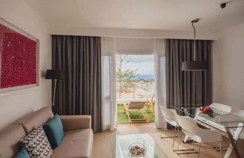 Un salon lumineux s'ouvre sur une terrasse avec vue sur la mer.