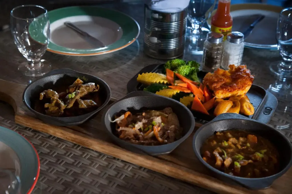 Assortiment de plats colorés servis sur une table en bois.