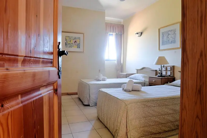Une chambre lumineuse avec deux lits simples et des décorations murales.