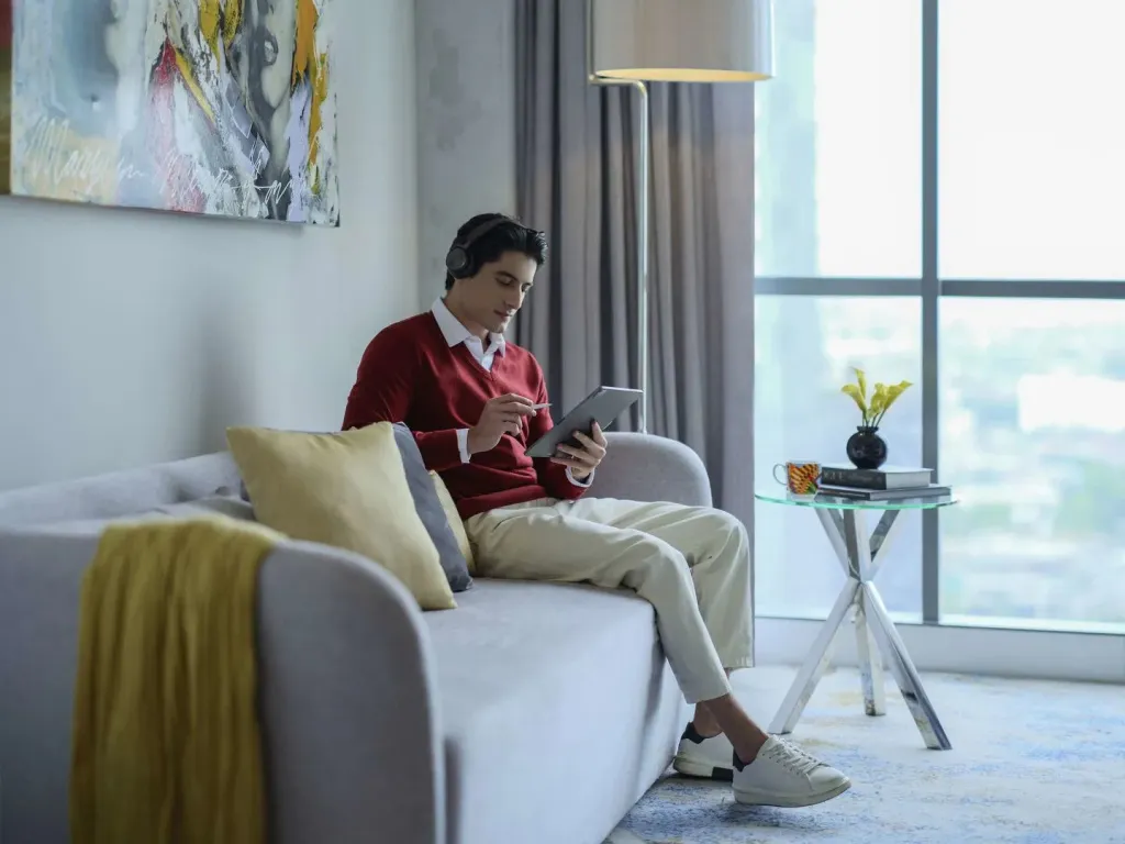 Un homme se détend sur un canapé dans un intérieur lumineux.