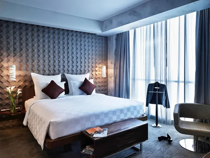 Une chambre moderne avec un grand lit et une fenêtre drapée.