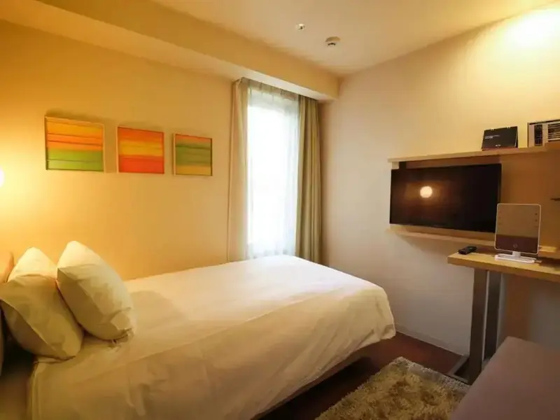 Une chambre lumineuse avec un lit simple et un bureau.