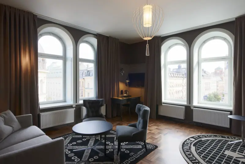 Espace de séjour lumineux avec canapés et vue sur la ville.