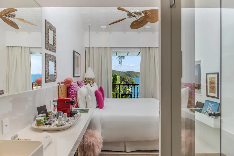 Une chambre lumineuse avec un grand lit et une vue sur la mer.