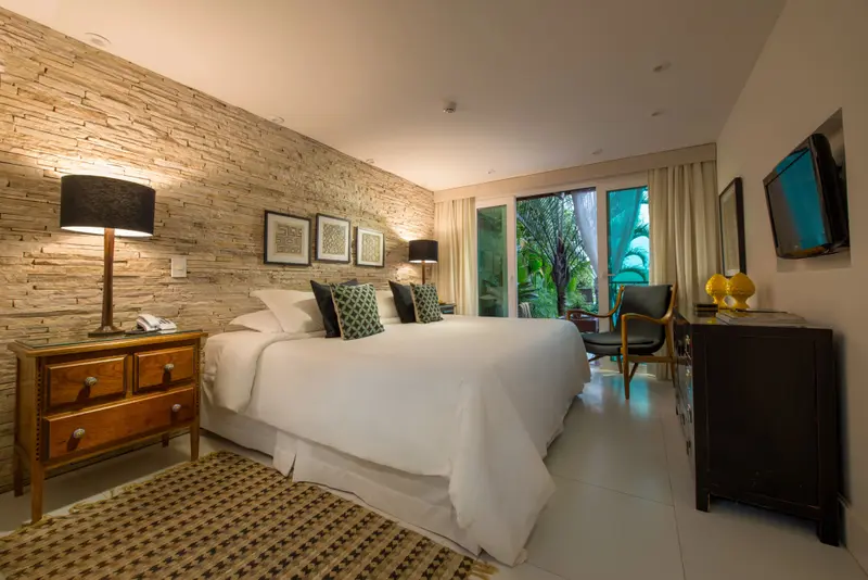Une chambre lumineuse avec un grand lit recouvert de draps blancs.