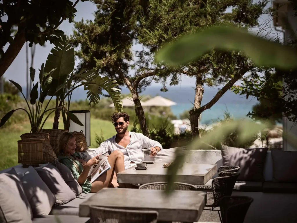 Un couple se détend sur un canapé en extérieur avec vue sur la mer.