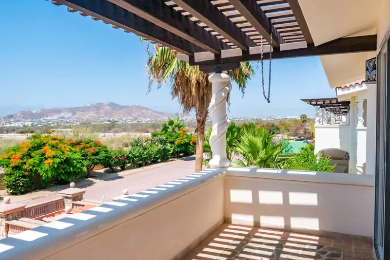 Terrasse ombragée donnant sur un paysage montagneux et une végétation luxuriante.