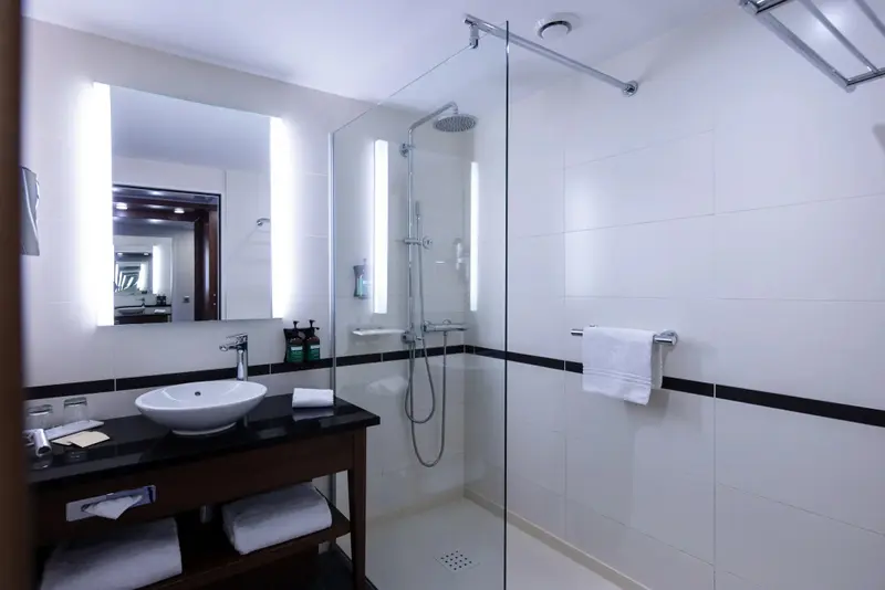 Une salle de bain moderne avec douche à l'italienne et vasque sur meuble.
