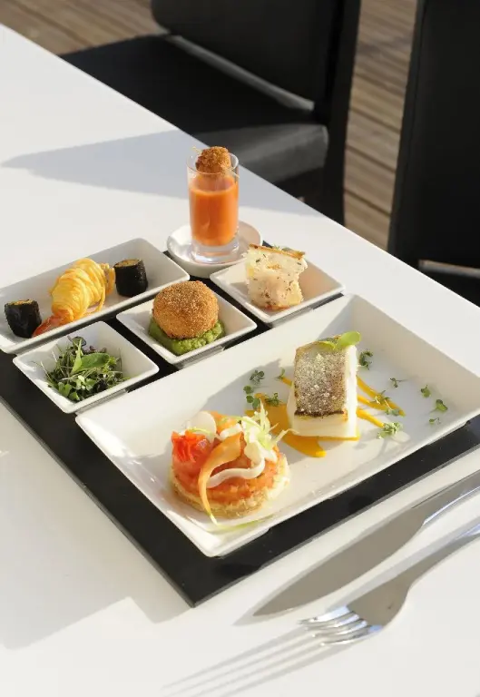 Assortiment de petites bouchées raffinées disposées sur une table blanche.