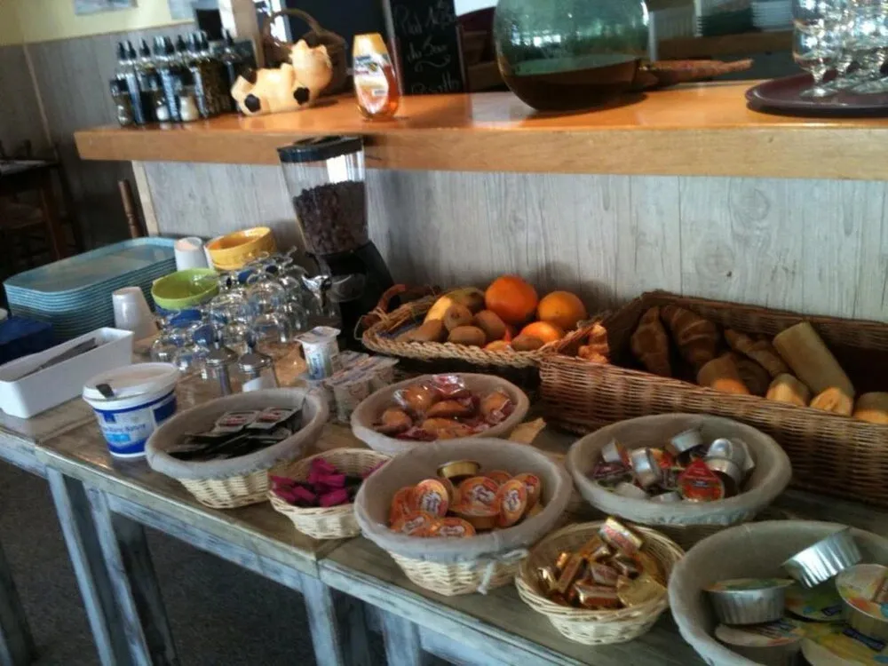 Un buffet propose des viennoiseries, des fruits et des confitures.