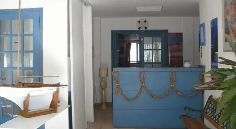 Un comptoir d'accueil bleu est décoré de cordes marines et d'une bouée.