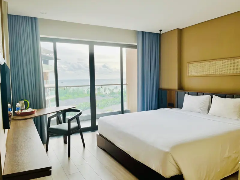 Une chambre lumineuse avec un grand lit et une vue sur la mer.