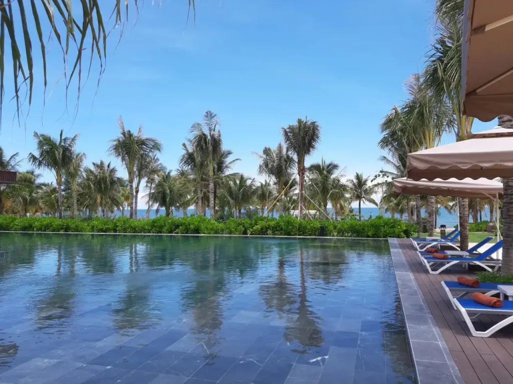 Une piscine à débordement offre une vue sur la mer et la végétation tropicale.