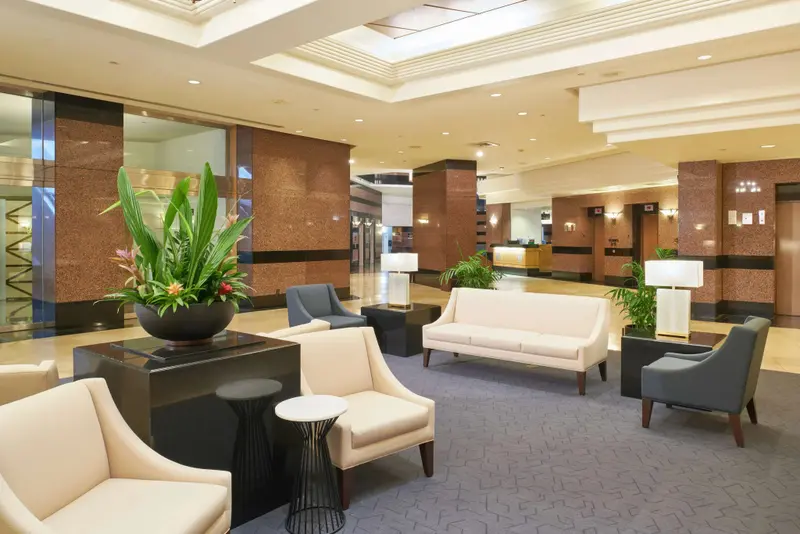Un hall d'accueil lumineux avec des fauteuils et canapés confortables.